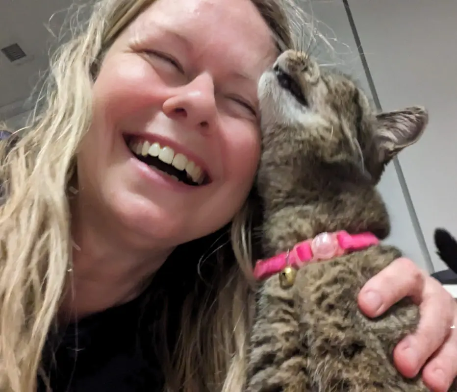 Cat Sitter Raisa laughing as Maggie the Cat rubs against her face